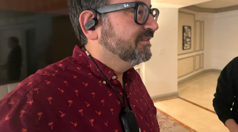 Me testing Ixana's prototype pendant and wireless earbuds for audio streaming over the Wi-R body network. The connection dropped just a few centimeters beyond my body but automatically reconnected once back in range.